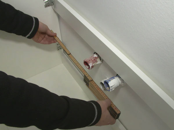 Opmåling inden skabet hænges op på væggen
