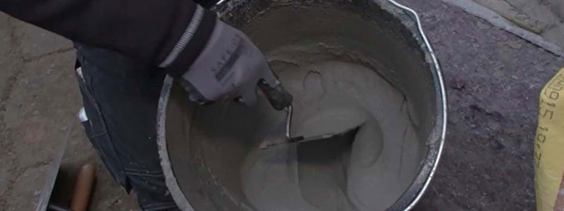 Mørtel blandes med en murerske i en spand