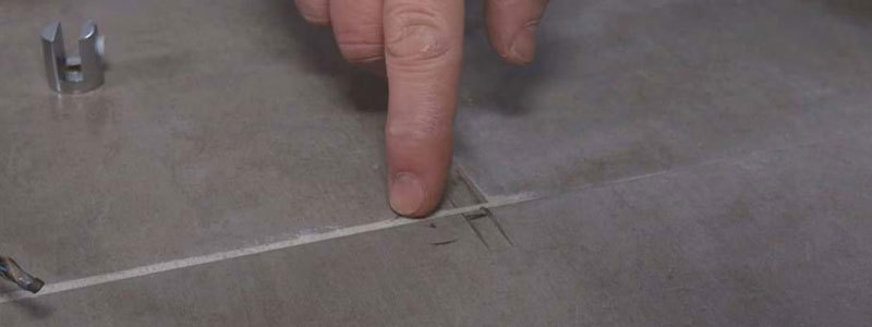Finger peger på markering på flisegulv