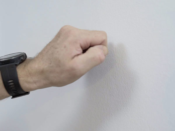 Hånd banker på væg, for at afgøre hvilken type væg det er
