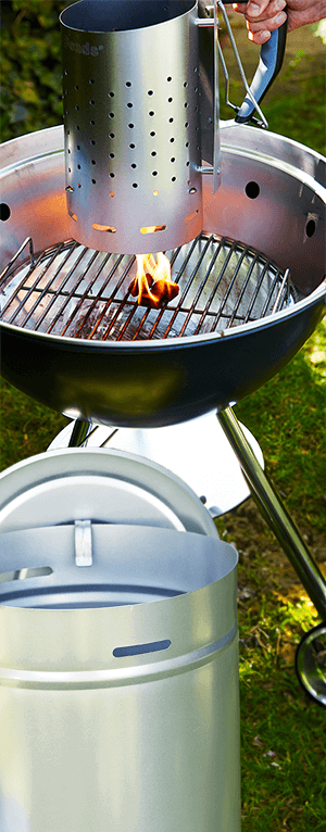 Grillstarter fyldt med kul antændes stående i grillen