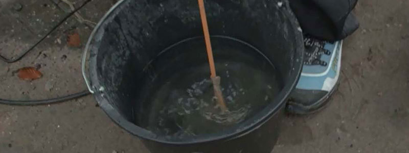 Piskeris på boremaskine rengøres i en spand med rent vand